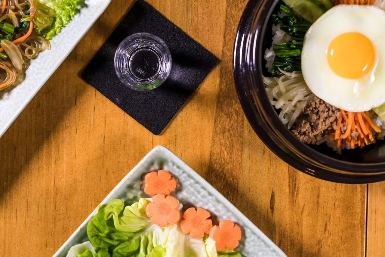 A stone bowl of bibimbap piled with seasoned vegetables and rice